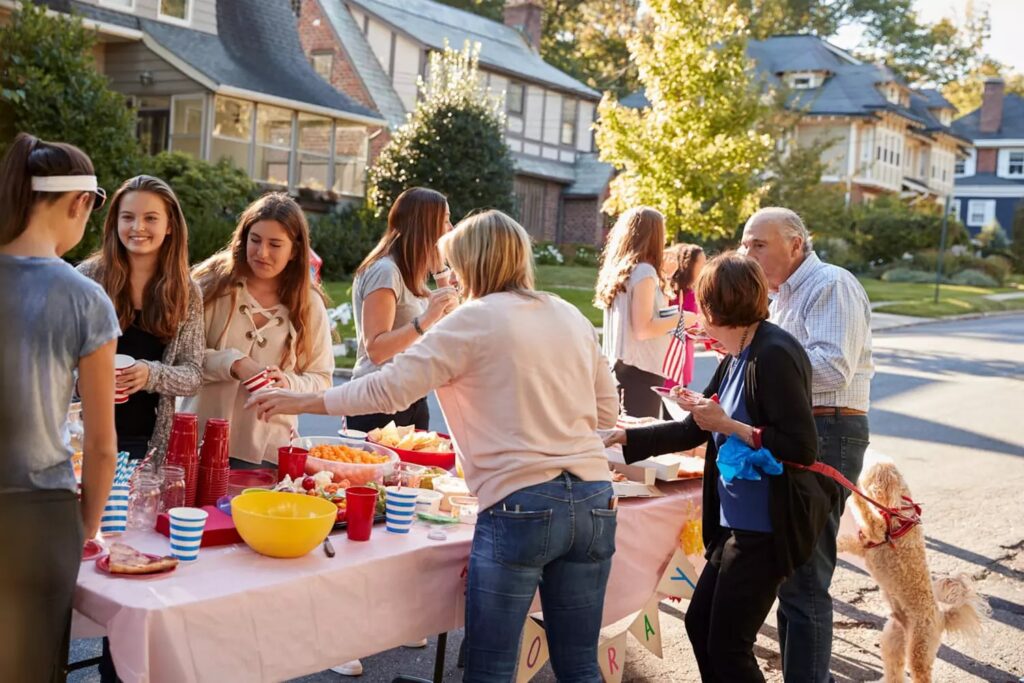 Voisins réunis autour d'un buffet convivial en extérieur
