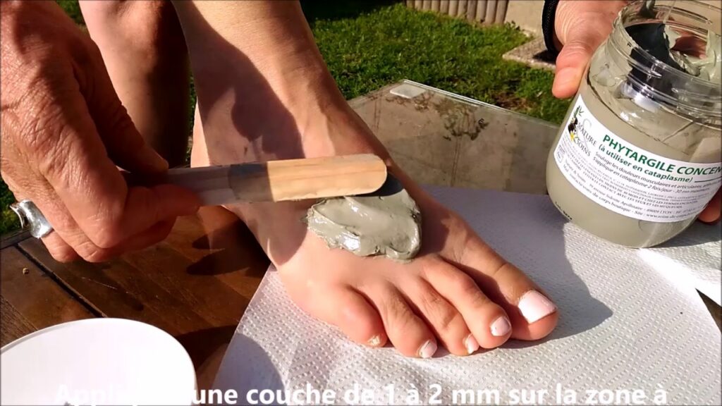 Tube de phytargile, gel de massage à l'argile verte posé sur une table en bois