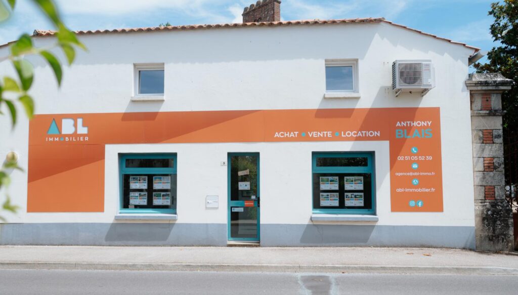 Vitrine d'une agence immo avec des annonces de maisons et d'appartements à vendre