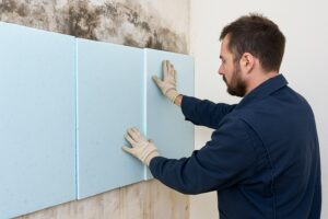 Pose d'un doublage isolant pour isoler un mur intérieur dans une pièce en rénovation